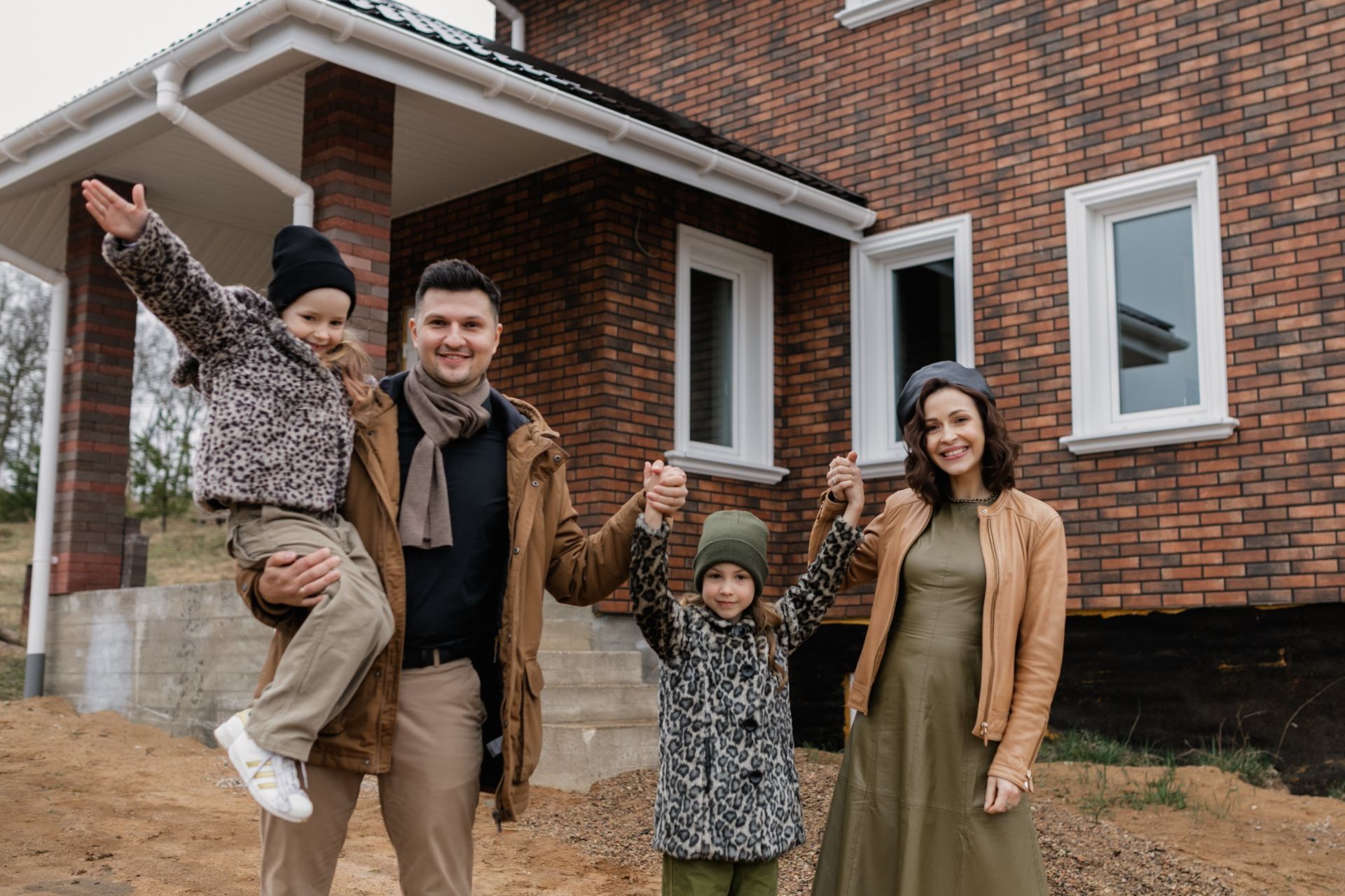 A Happy Family Standing in Front of Their House Grateful for Benafor sprinkler service